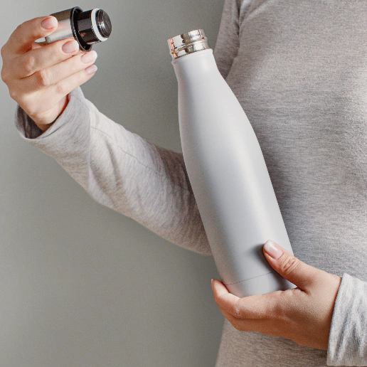 a person holding a metal bottle